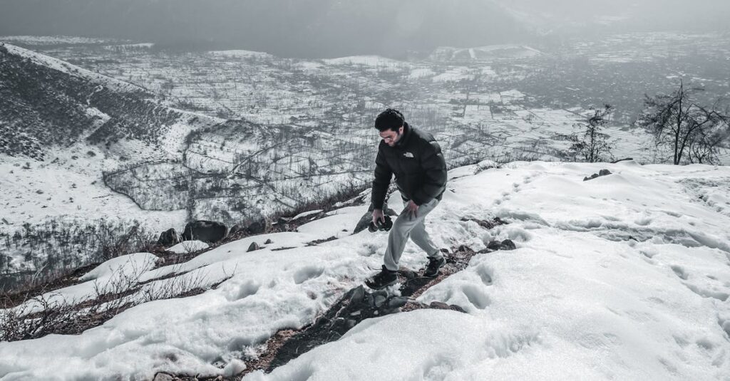 Single hiker climbing snowy mountain in Kashmir, showcasing winter adventure and scenic landscape.