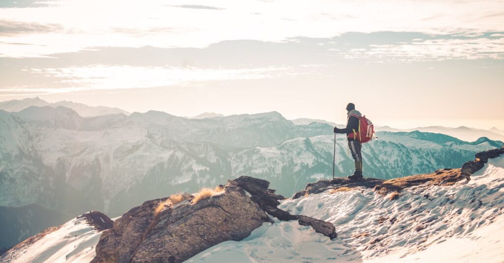 A backpacker standing atop snowy mountains, exploring the serene Himalayan landscape.